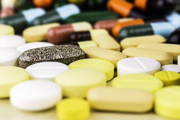 Medicine pills or capsules on wood background.Drug prescription for treatment medication.Pharmaceutical medicament,cure for health.Pharmacy theme, capsule pills with medicine antibiotic in packages.