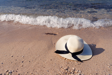 Obraz premium White straw hat on the beach,relaxing and holiday concept.