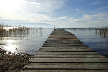 Fototapeta premium Old wooden pier by the Ohrid Lake with a cloudy sky on an autumn day