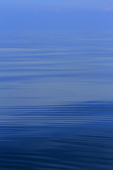 ripple a small wave or series of waves on the surface of water, especially as caused by an object dropping into it or a slight breeze.