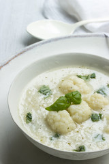 Blumenkohlsuppe mit Basilikum in einer weißen Suppenschale