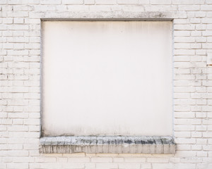 white painted brick wall with blind window of old building