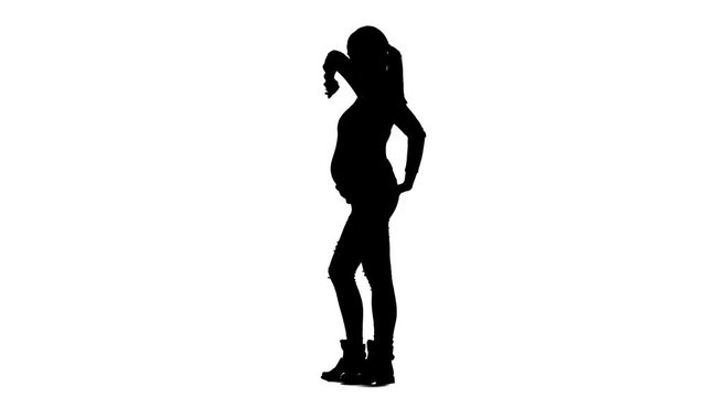 Girl expects the birth of the baby, she is pregnant and her back hurts. Silhouette. White background. Slow motion