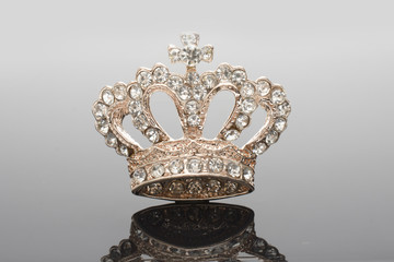 golden brooch crown isolated on black © vitaly tiagunov