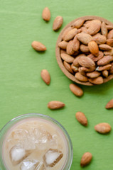 Ice coffee and blur almonds on green background
