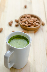 Hot green tea latte in lazy time with almonds nut