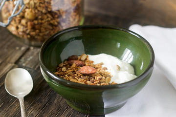 Useful breakfast is yoghurt with granola. Granola with yoghurt in a ceramic bowl and granola in a glass.