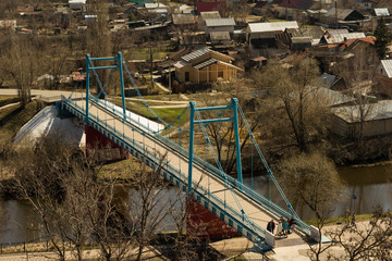 A blue, old foot bridge across the river in Tambov.