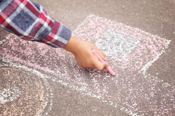 Little child drawing car with chalk on asphalt, closeup