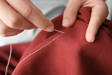 Woman sewing by hand, closeup