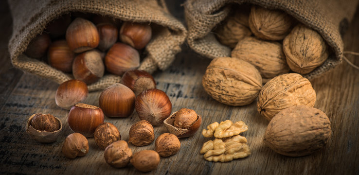 Walnuts and Hazelnut in jute bag on wooden background