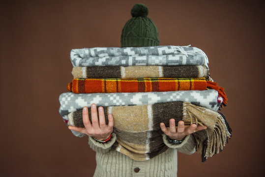 man holding pile of blankets
