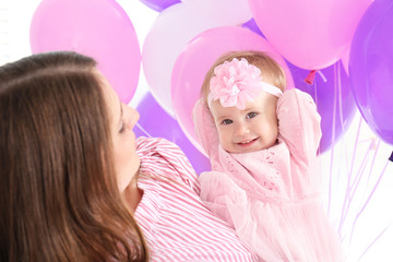 Young mother and cute baby celebrating birthday at home