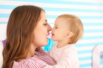 Young mother and cute baby at home