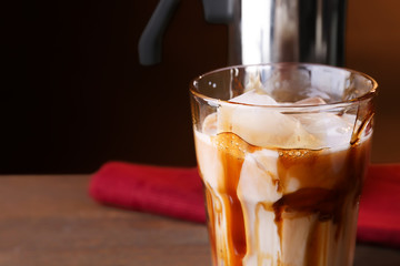 Glass with cold latte macchiato on blurred background