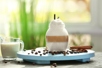 Jar with latte macchiato on wooden board