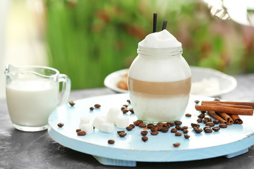Jar with latte macchiato on wooden board