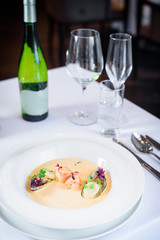 Plate of tasty cream of sea food soup with shrimps and mussels on table