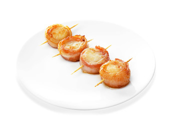 Plate with bacon wrapped scallops on white background
