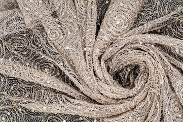 Texture, fabric, background. Lace fabric with a pattern of a circle, with a thread of gold thread