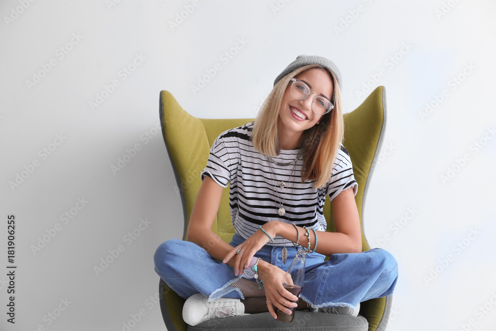 Wall mural attractive hipster girl in armchair