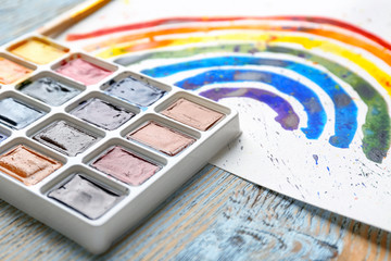 Watercolor painting of rainbow on wooden background, closeup