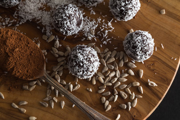 Coconut energy balls with spoonful of cacao powder