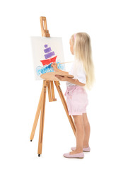 Naklejka premium Cute little girl painting picture on canvas against white background