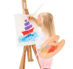 Naklejka premium Cute little girl painting picture on canvas against white background