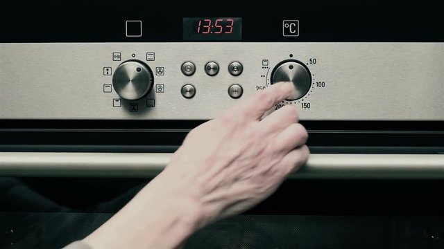 Oven panel /The woman turns on the oven and sets the temperature
