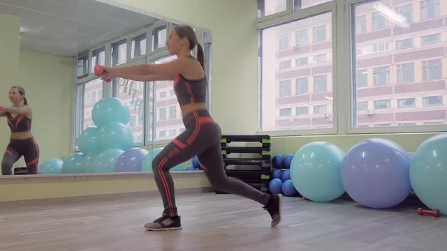 Young woman doing fitness indoors, doing stretching. girl shakes the press. healthy lifestyle and sports. the camera moves.