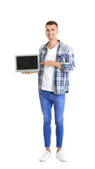 Young man pointing at laptop screen against white background