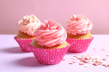 Yummy cupcakes on color background