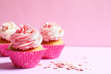 Yummy cupcakes on color background