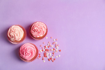 Yummy cupcakes on color background