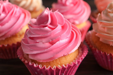 Yummy cupcakes on wooden table, closeup