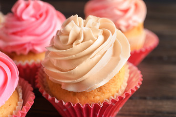 Yummy cupcakes on wooden table, closeup