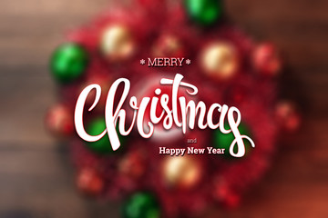 The inscription of Merry Christmas and Happy New Year, a wreath on a wooden brown table. Christmas card, holiday background. Mixed media.