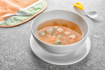 Plate with tasty baby soup on table