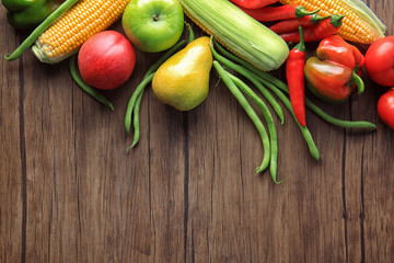 Composition of different fruits and vegetables on wooden background