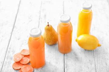 Bottles with fruit and vegetable juices on wooden table