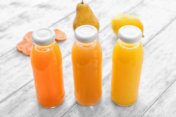 Bottles with fruit and vegetable juices on wooden table