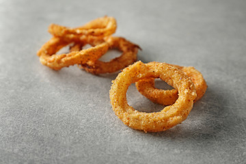 Fried onion rings on grey background