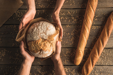 whole wheat bread in hands - obrazy, fototapety, plakaty