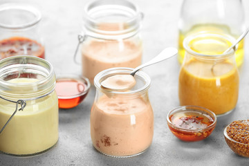 Jars with tasty sauces for salad on table
