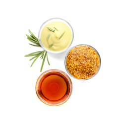Gravy boats with tasty sauces for salad on white background