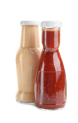 Bottles with different sauces for salad on white background