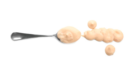 Spoon with tasty sauce for salad on white background