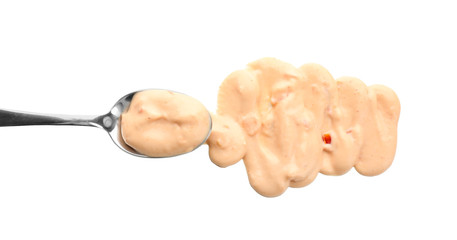 Spoon with tasty sauce for salad on white background