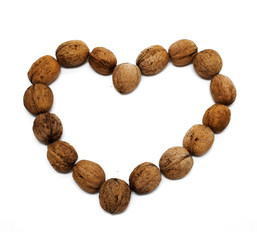 Nuts lie in the shape of heart on a white background